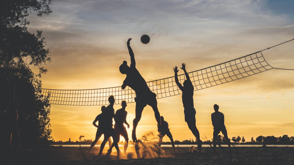 Viele Menschen spielen Volleyball im Urlaub und in ihrer Freizeit am Strand