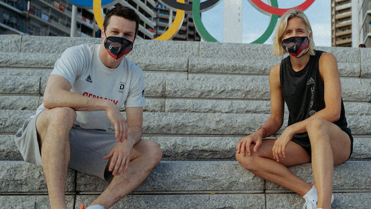 Laura Ludwig und Patrick Hausding tragen die Fahne ins Stadion